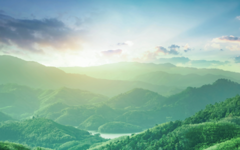 A landscape scene of verdant mountains and a river